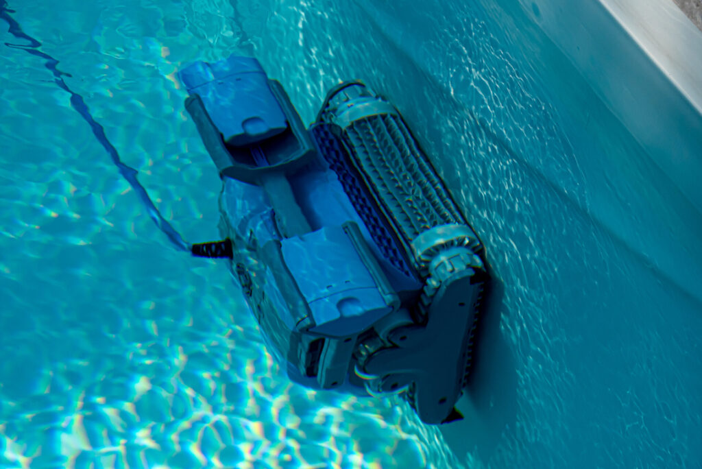 Ein Pool Bodensauger fährt über die Innenwand eines Swimmingpools