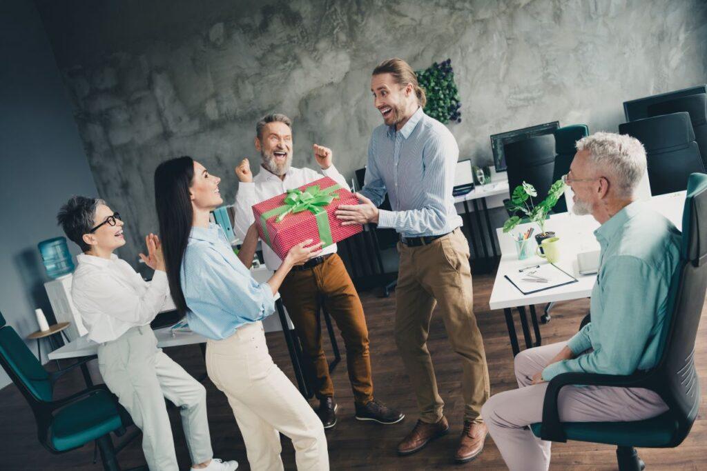 Team freut sich über ein großes Geschenk als Beispiel für gelungene Kundengeschenke im Arbeitsumfeld