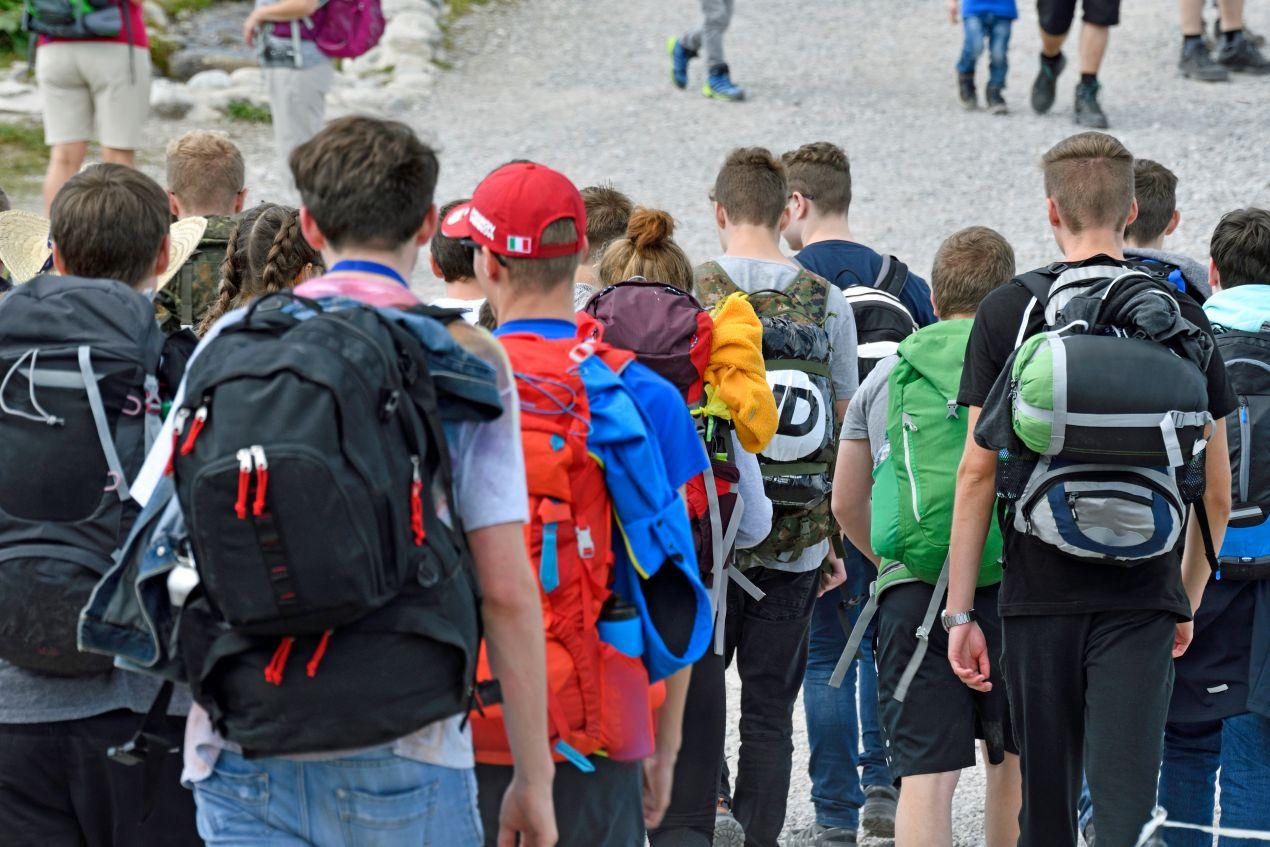 Klassenfahrt Berlin: Schülergruppe mit Rucksäcken auf dem Weg zu einem Tagesausflug in der Hauptstadt