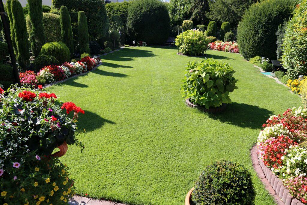 Gartenbau Mannheim mit gepflegtem Rasen, symmetrischer Beetgestaltung und professioneller Bepflanzung im Privatgarten