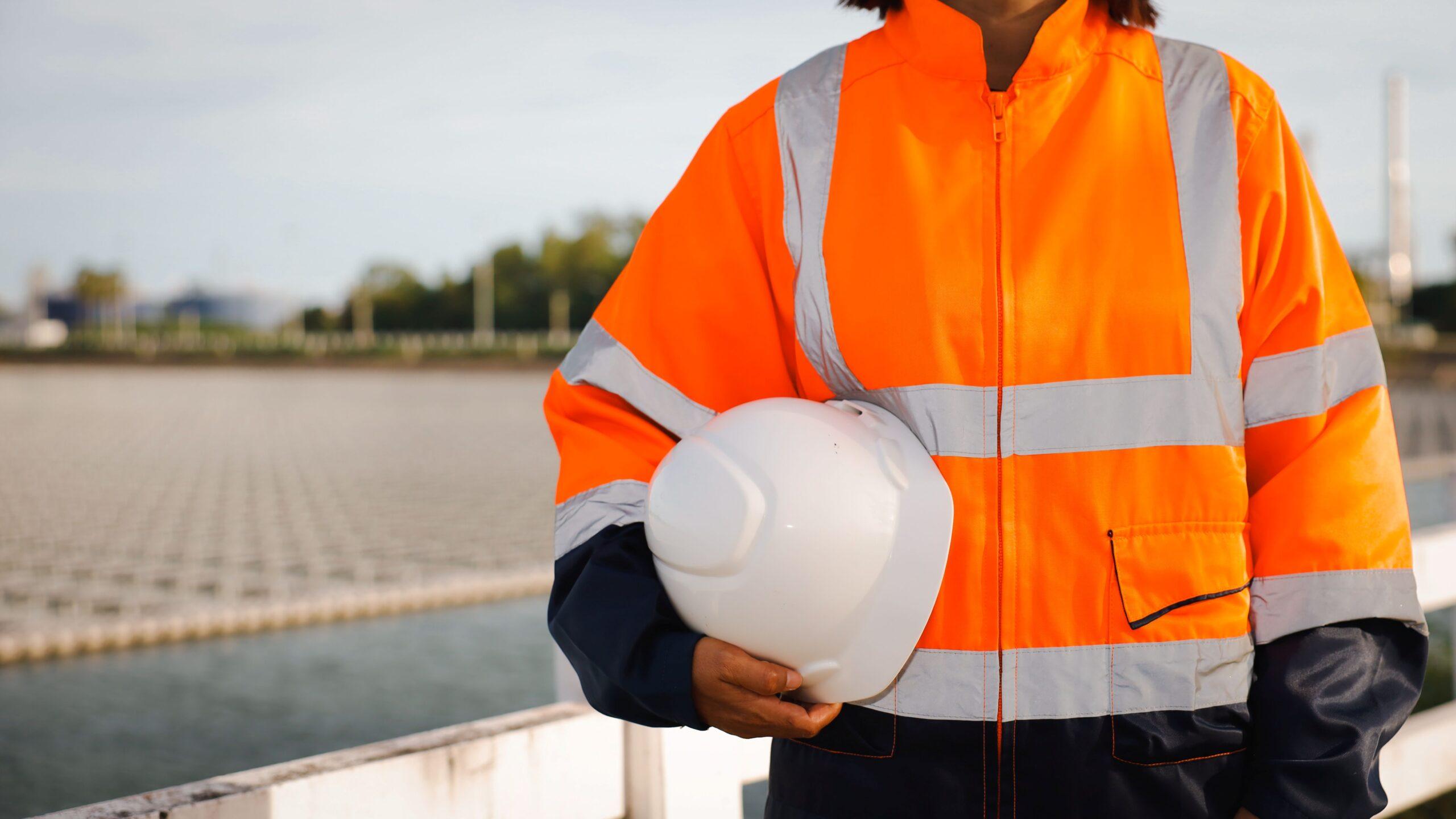Person in Sicherheitskleidung mit Helm in der Hand – bereit zur Übergabe nach Abschlussarbeiten