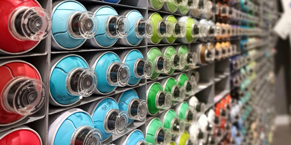 Sortierte spraydosen in verschiedenen farben als werkzeug fuer professionellen graffiti auftrag und wandgestaltung