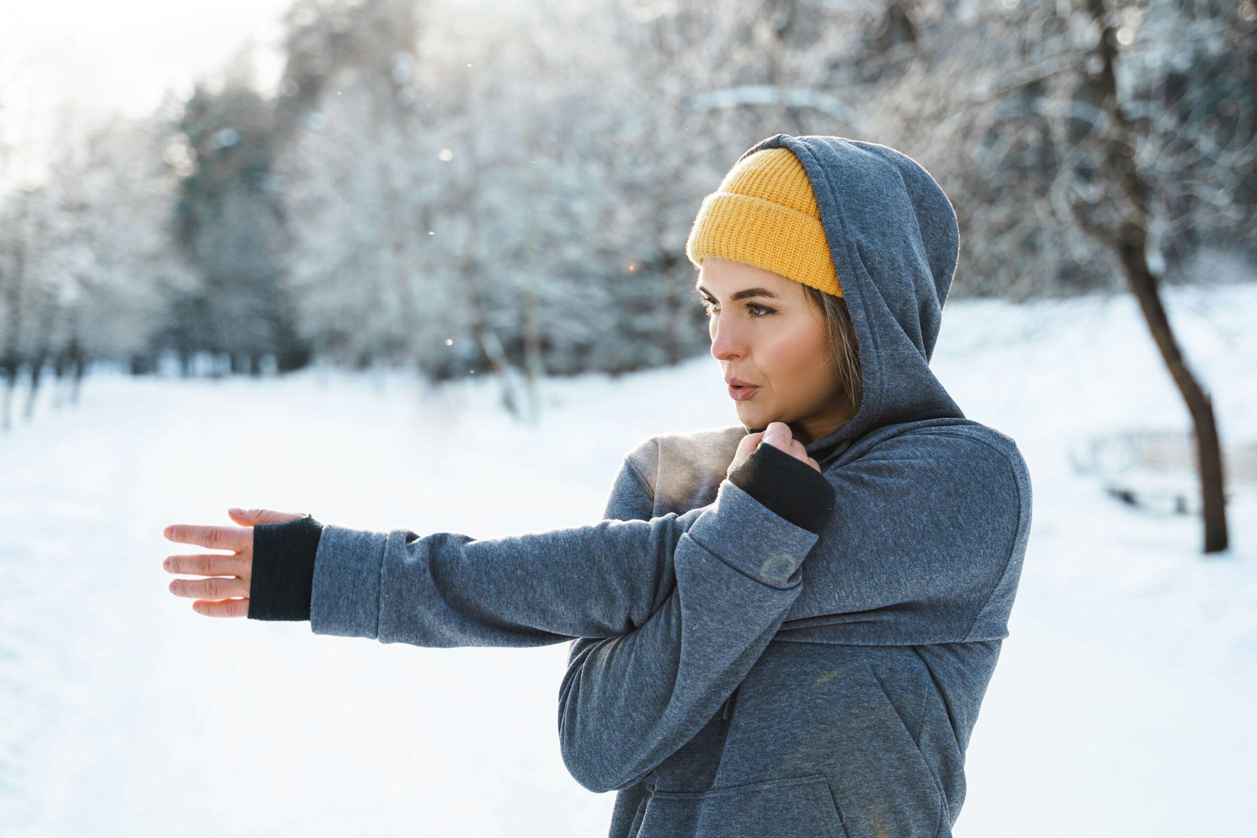 Junge sportliche Frau beim Aufwärmen vor ihrem Wintertraining