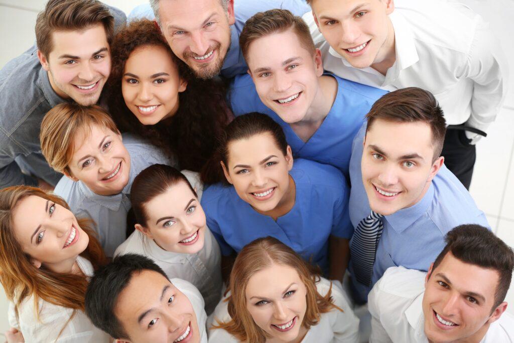 Lachende Gruppe unterschiedlicher Mitarbeiter blickt hoch | Anwalt Arbeitsrecht Bonn